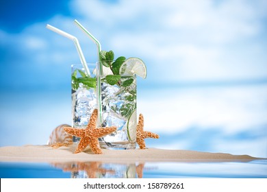 Mojito Cocktail With Ice, Rum, Lime And Mint   In A  Glass  On Beach Sand And  Idyllic Tropical Seascape