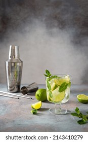 Mojito Cocktail Or Mocktail With Lime, Mint, And Ice In A Glass On A Gray Background. Summer Cold Alcoholic Non-alcoholic Drink, Beverage And Cocktail Recipe. Bar Menu. Copy Space. Steel Bar Tools