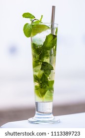 Mojito Cocktail On A Beach  With A Metal Straw With A White Sea View Background