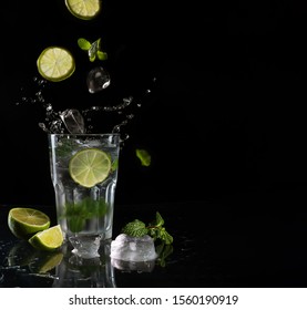 Mojito cocktail on black background with flying ingredients with copy space - Shutterstock ID 1560190919