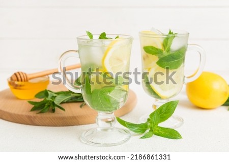 Mojito cocktail. Refreshing mojito cocktail with lime, lemon and mint in a tall glass with a stick.