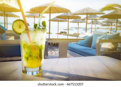 Mojito drink on the stone table. Beach bar background.