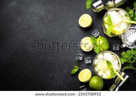 Mojito with rum and lime on black background.