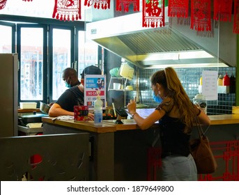 Mojo Market- Cape Town, South Africa - 12-03-2020

Young Woman Wearing A Face Mask, Placing An Order At A Food Stall. Hand Sanitizer And A 