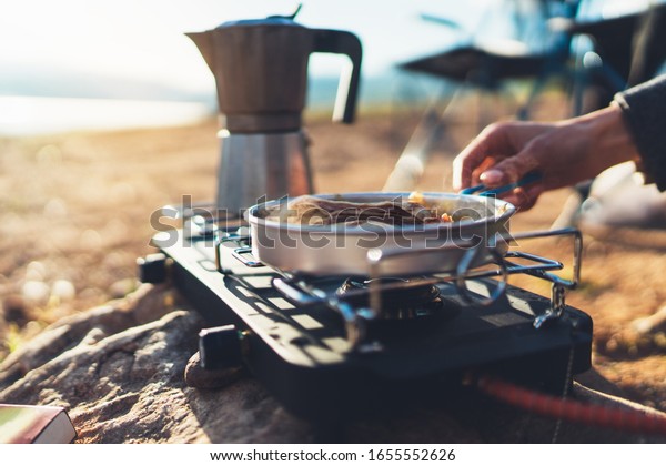 moka pot coffee campsite morning\
lifestyle, person cooking hot drink in nature camping\
outdoor