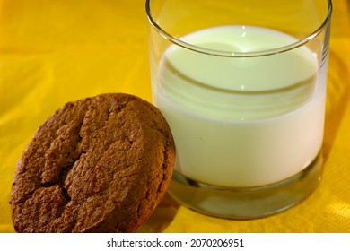 A Molasses Cookie With A Glass Of Milk On A Yellow Napkin 