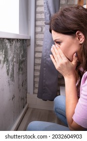 Mold Damage On House Wall. Woman Looking At Wet Moisture