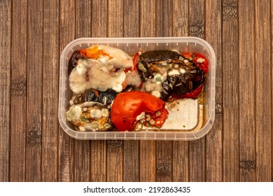 Mold Spores On Fried Vegetables In A Plastic Food Container On A Textured Wooden Background. Concept: Decomposition Products, Food Poisoning.