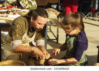 Moldavanskoye, Krymsk, Russia-05 October 2019: A Potter Teaches A Girl How To Make A Pitcher Of Clay. Master Class At The Young Wine Festival In Lefkadia