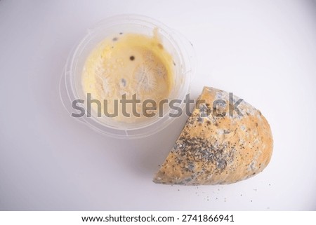 Moldy bread and melted cheese in a container. Spoiled Dairy Product