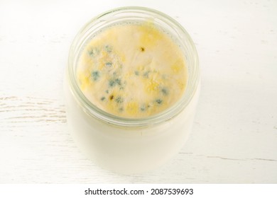 Moldy Yogurt, Growth Of Mold On Yogurt Or Dairy Product Food Surface Exceeded Expiry Date. Rotten Yoghurt Or Milk Background