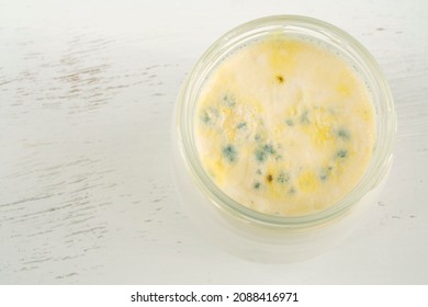 Moldy Yogurt, Top View Of Rotten Moldy Yogurt Or Yoghurt In Jar On Wooden Background. Rotten Dairy Product Or Milk On Table