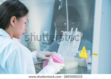 Molecular biologist executing qpcr amplification protocols using micropipette. Genomic researcher preparing dna sequencing samples in sterile biosafety cabinet.