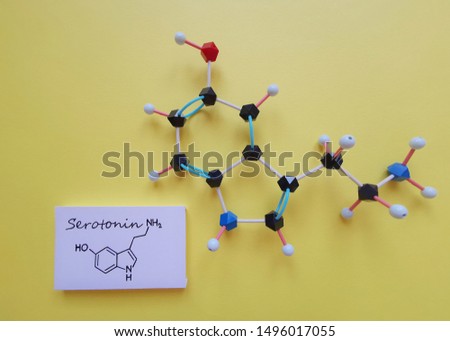 Molecular structure model and structural chemical formula of serotonin molecule. Serotonin is a monoamine neurotransmitter, and it is also called Hormone of Happiness. Black=C, red=O, blue=N, white=H.