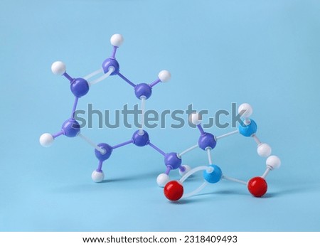 Molecule of phenylalanine on light blue background. Chemical model