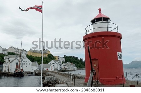 Molja Lighthouse in old port of Alesund, Norway. Molja lihgthouse in the front of Olaf Holf warehouse building, Fisheries Museum(fishing industry).