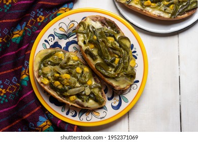 Molletes with poblano rajas and cheese on white background. Traditional mexican food