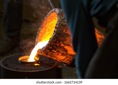 Molten Bronze Poured Into Mold By Melter In Foundry Workshop