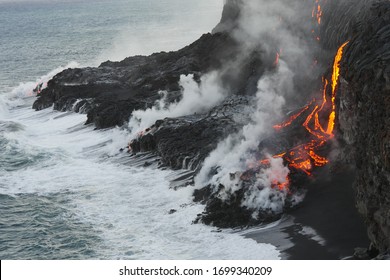 Molten lava flowing into the Pacific Ocean on Big Island of Hawaii, as ocean waves splash onto the rocks and flowing lava - Powered by Shutterstock