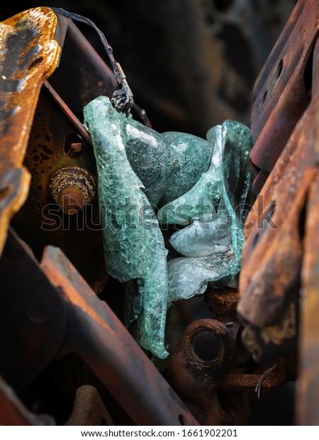 Molten melted glass from fire\
heat in a burnt vehicle car wreck junk scrap with a rusty steel\
frame