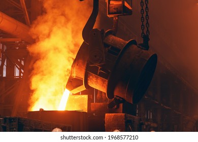 Molten metal pour from big container Into sand mold with sparks. Iron casting in metallurgy foundry plant, heavy industry - Powered by Shutterstock