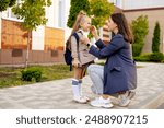 mom accompanies her first-grader daughter to school, kissing her and hugging her, back to school, the parent gives the child to the first grade. Mom meets a student from school.