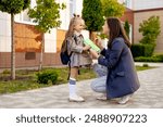 mom accompanies her first-grader daughter to school, kissing her and hugging her, back to school, the parent gives the child to the first grade. Mom meets a student from school.