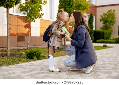 mom accompanies her first-grader daughter to school, kissing her and hugging her, back to school, the parent gives the child to the first grade. Mom meets a student from school.