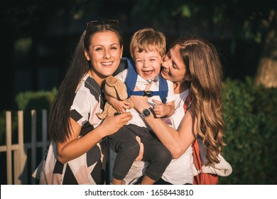 Mom and aunt holding cute, little boy while he is laughing . Family love - Shutterstock ID 1658443810