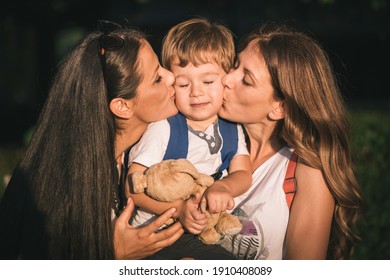 Mom and aunt holding and kissing cute, little boy. Family love - Shutterstock ID 1910408089