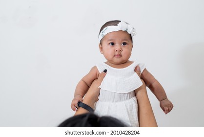 Mom And Baby. Happy Mommy Lifting Up Her Baby, Adorable Child Daughter Enjoying With Cheerful Expression. 