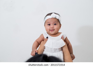 Mom And Baby. Happy Mommy Lifting Up Her Baby, Adorable Child Daughter Enjoying With Cheerful Expression. 