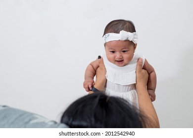 Mom And Baby. Happy Mommy Lifting Up Her Baby, Adorable Child Daughter Enjoying With Cheerful Expression. 