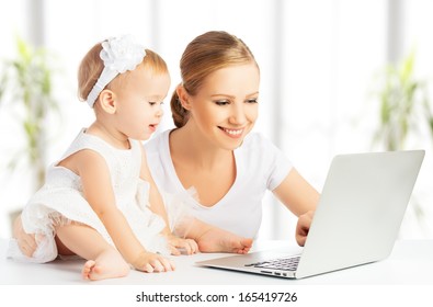 Mom and baby with laptop computer working from home