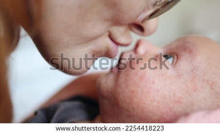 mom baby newborn close up. dream kindergarten a family concept. mom play with a newborn baby touches her nose close-up of her face. mother lifestyle caring for newborn baby