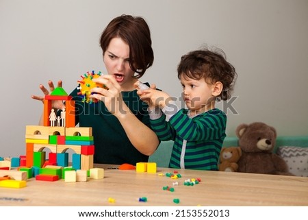 Mom and baby play at home. Explain to the child what the virus is in a playful way. 