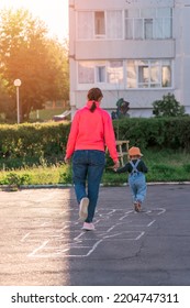 Mom And Baby Play Hopscotch On The Playground