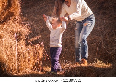 Mom And Baby Play Together In The Open Air In The Afternoon. Games In Nature. Farm Days. Giant Haystack And Family On It. Pediatric Hyper Activity And Attention Deficit Disorder. Sheet Horizontal 