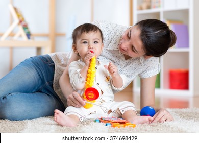 mom and baby playing musical toys at home