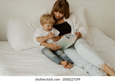 Mom baby sitter and cute little kid son read book fairy tale in bed, cute small child boy listening to mom learn reading in bedroom in morning. Happy little boy listen and smiling - Powered by Shutterstock