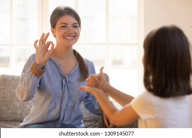 Mom Baby Sitter Teacher Or Psychologist Playing With Little Girl Showing Like Ok Signs By Hands Developing Child Motor Concept, Happy Mother And Kid Daughter Having Fun,  Sign Language, Deaf Gesture