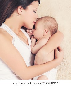 Mom And Baby Sleeping On The Bed, Top View. Gentle, Warm Feelings Of Mother