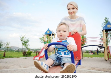 Mom And Baby Son Play In The Playground