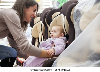 Mom With   Baby In   Store Buying   Car Seat.