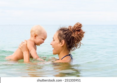 Mom And Baby Are Swimming In The Sea