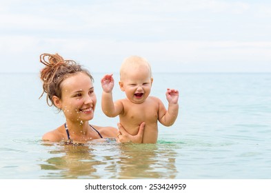 Mom And Baby Are Swimming In The Sea