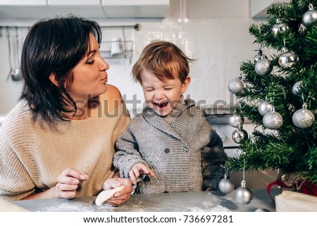 Mom Blows Her Son On The Background Of The Christmas Tree The Child Having Fun Mom Blows Her Son On The Background Of The Christmas Tree The Child Having Fun