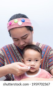 Mom Brushes Baby's Teeth With Gauze That Fits On Her Finger. Kids Hygiene Concept