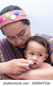 Mom Brushes Baby's Teeth With Gauze That Fits On Her Finger. Kids Hygiene Concept