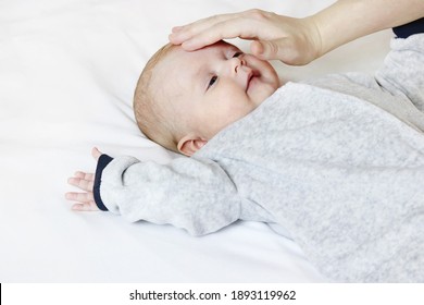 Mom Checks The Temperature Of A Sick, Sad Baby At Home. Copy Space - The Concept Of Childhood Diseases, Child Health Problems, Treatment, Immunity, Body Diagnostics